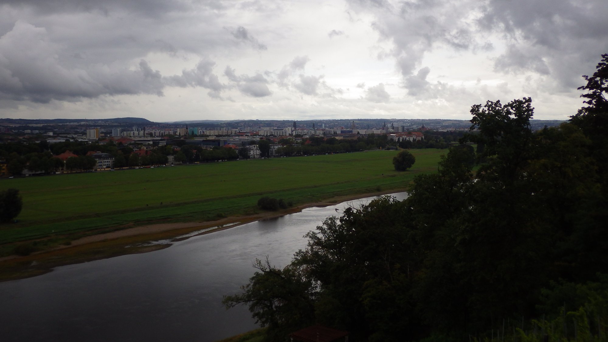 A brief view across the Elbe river and parts of Dresden, stormy clouds above.